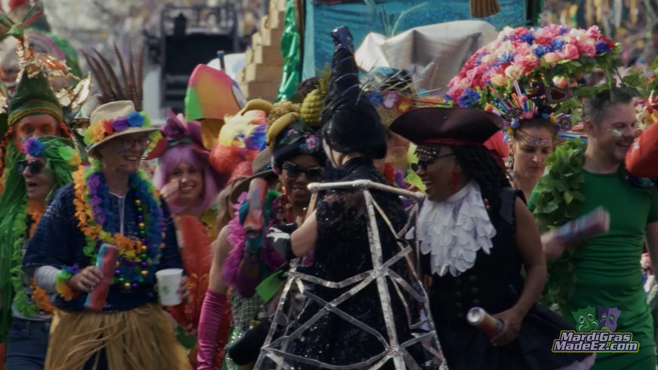 Costumed drummers marching through a crowded New Orleans street