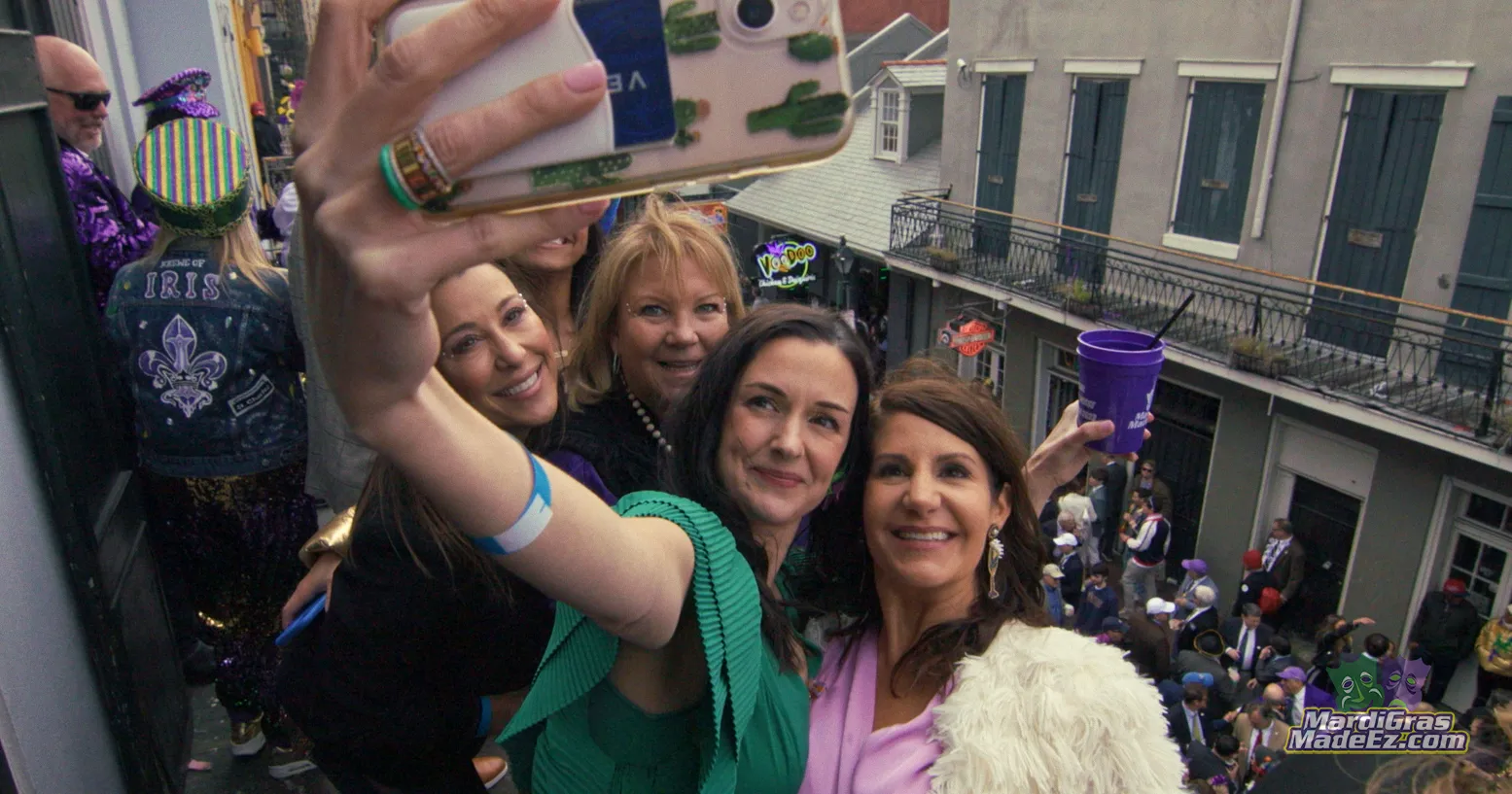 Guests taking a selfie on a balcony above a crowded street